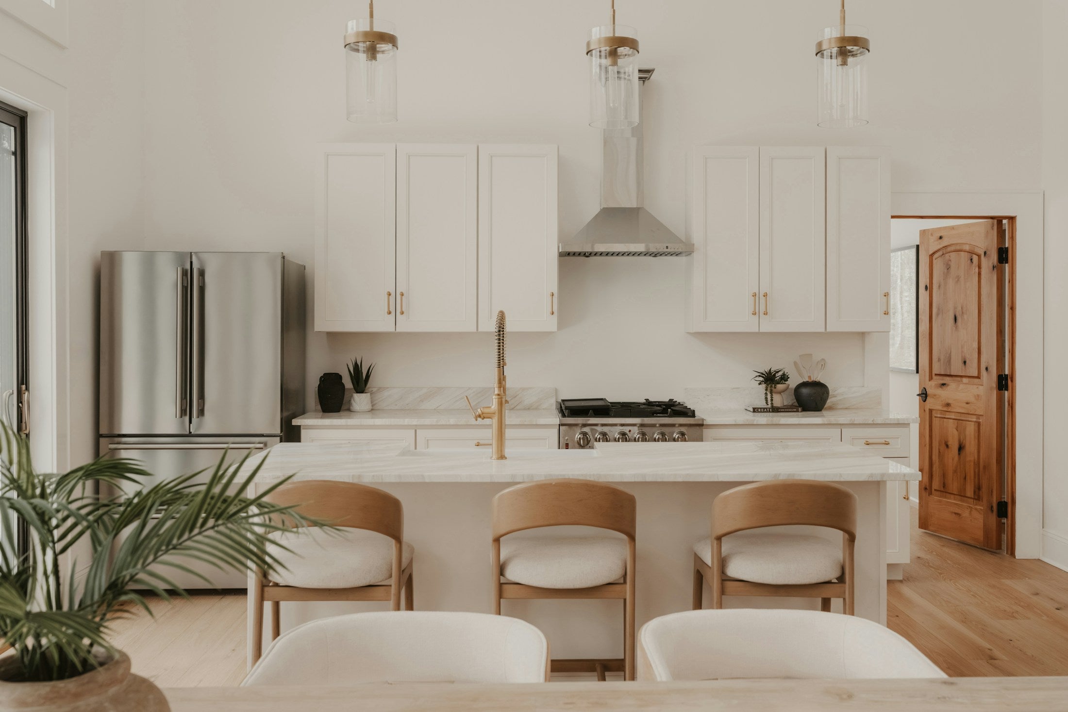 A light-filled kitchen with a brass faucet